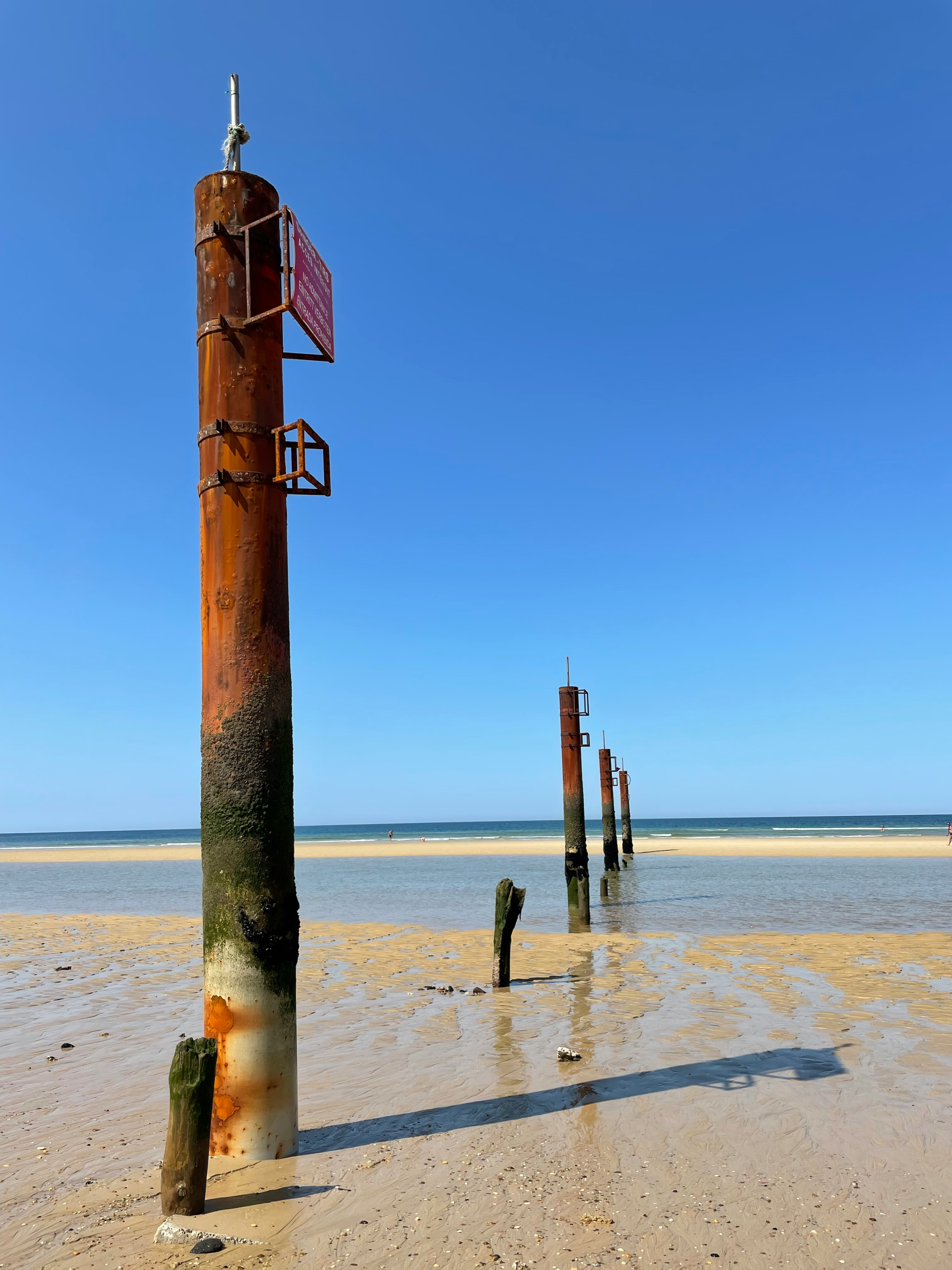 brown wooden post on beach during daytime